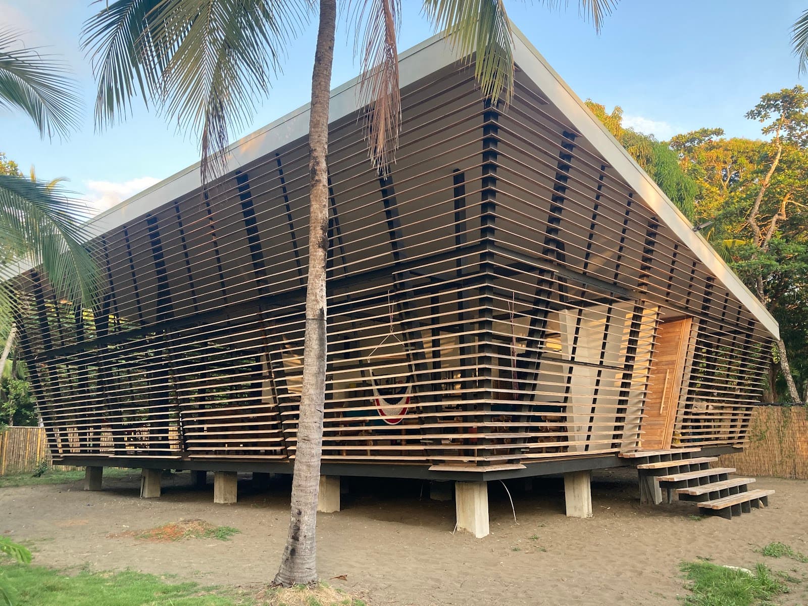 The No-Footprint House glowing at evening within the jungle