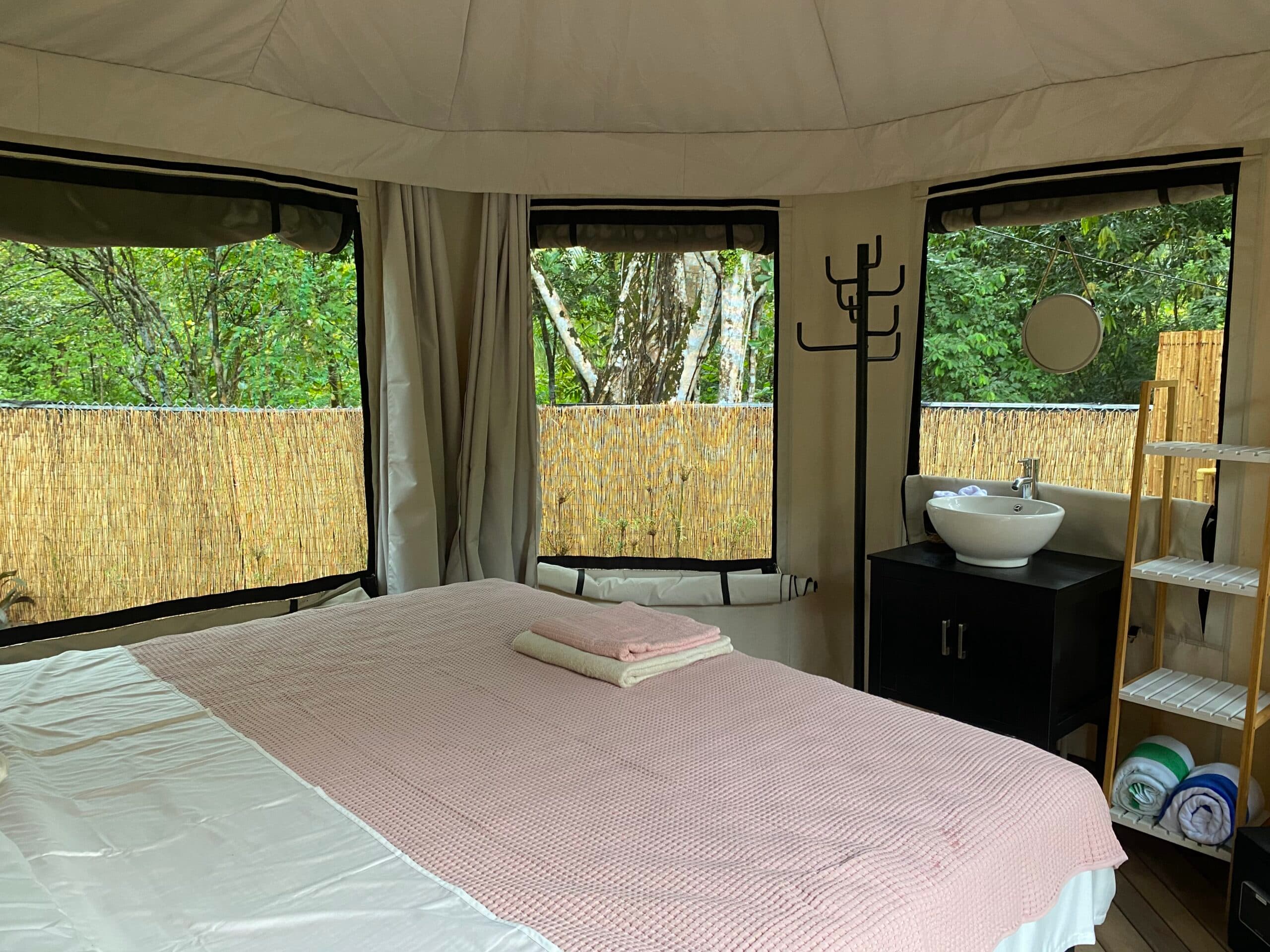 A tent bedroom, canvas above and jungle in every window