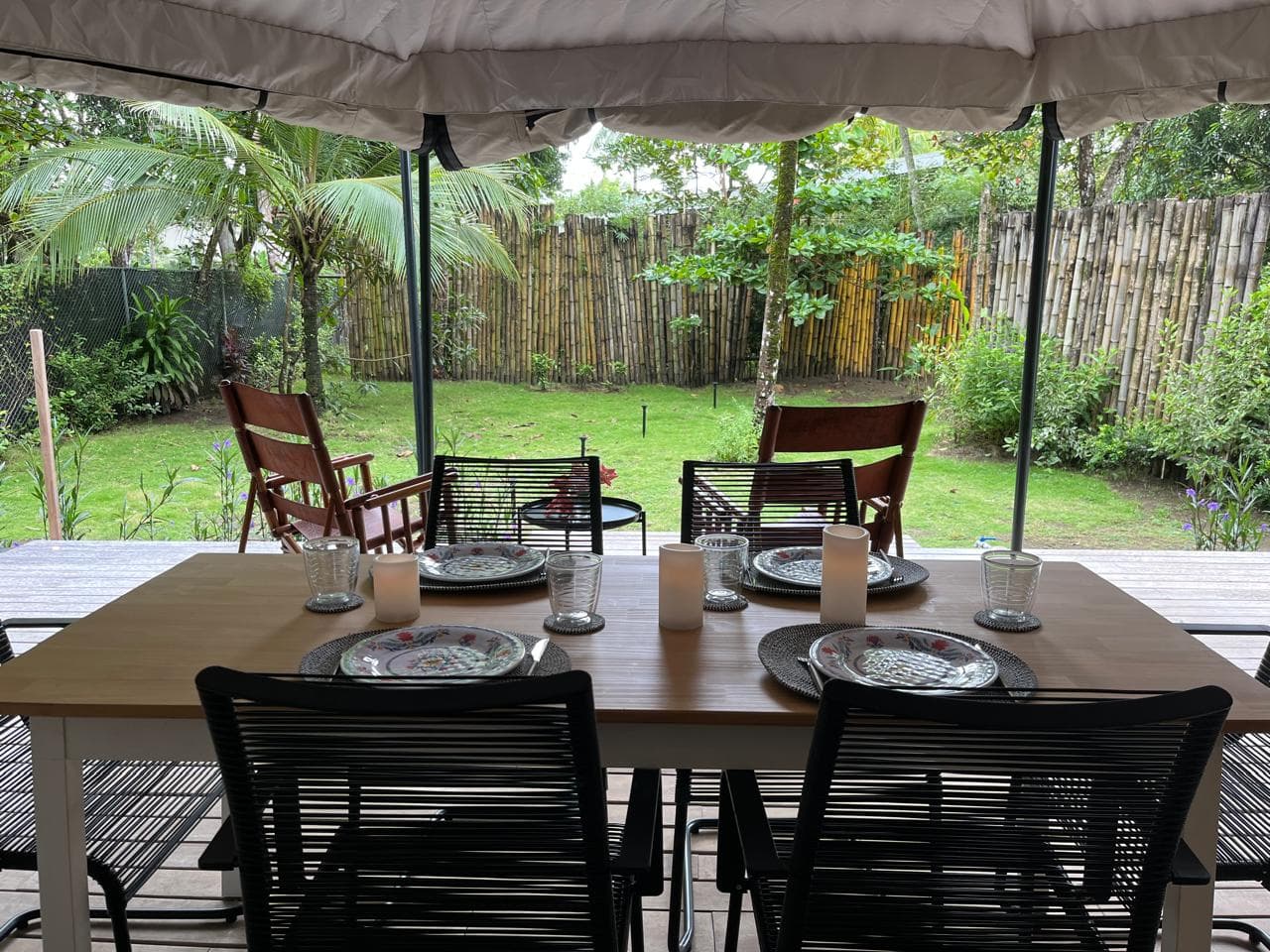 A table set for dinner in a safari tent, open to the garden